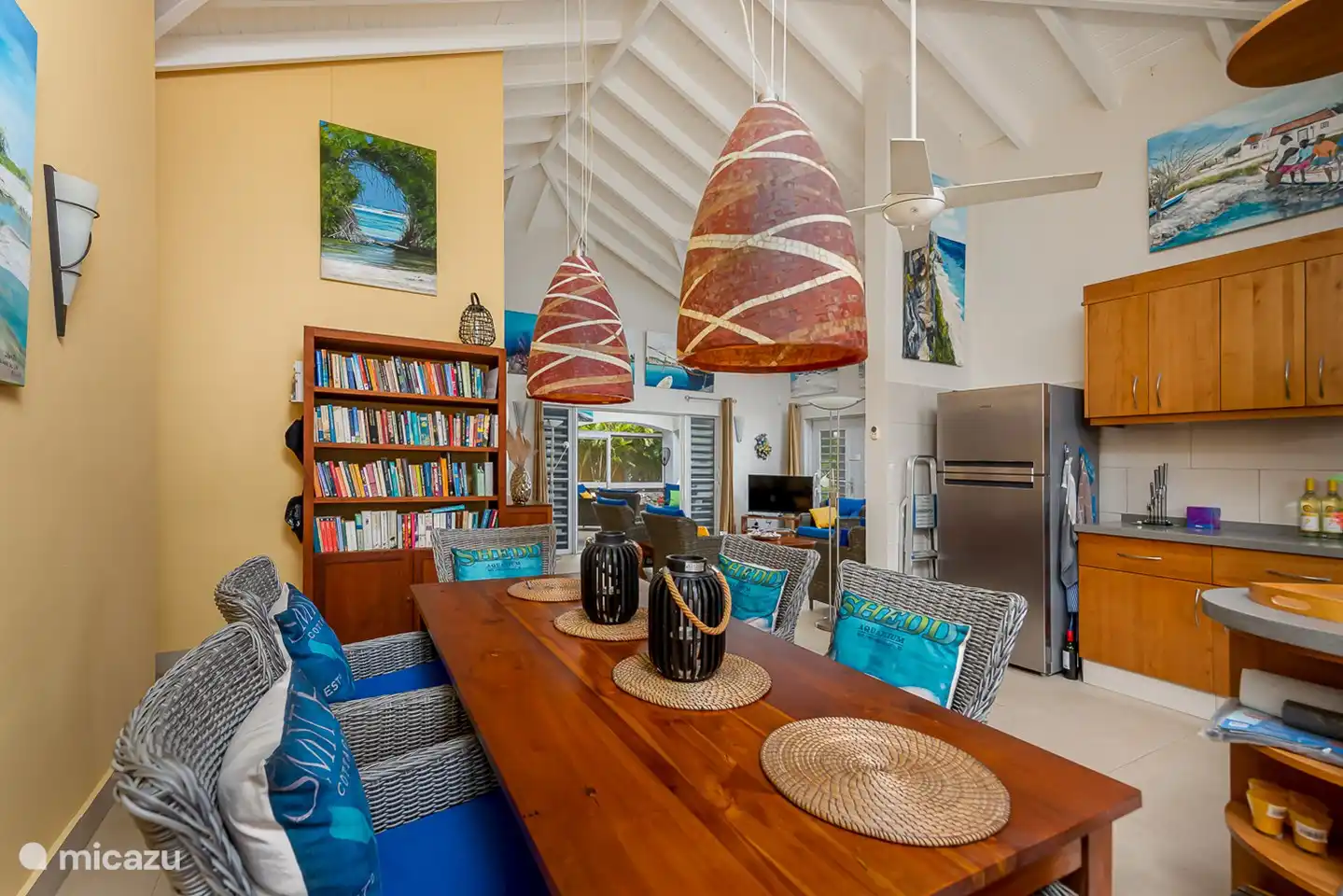 Zicht vanuit de keuken naar de woonkamer zithoek met de erachter gelegen buiten zit/eethoek