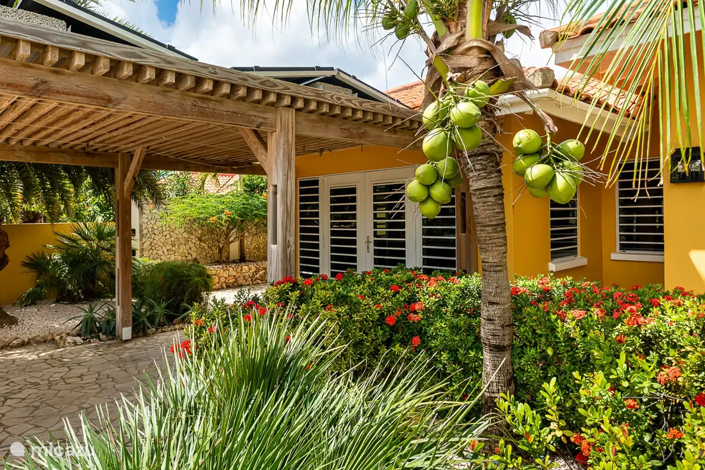 Overdekte carport   aan de voorzijde van het huis met daarop 8 zonnepanelen 