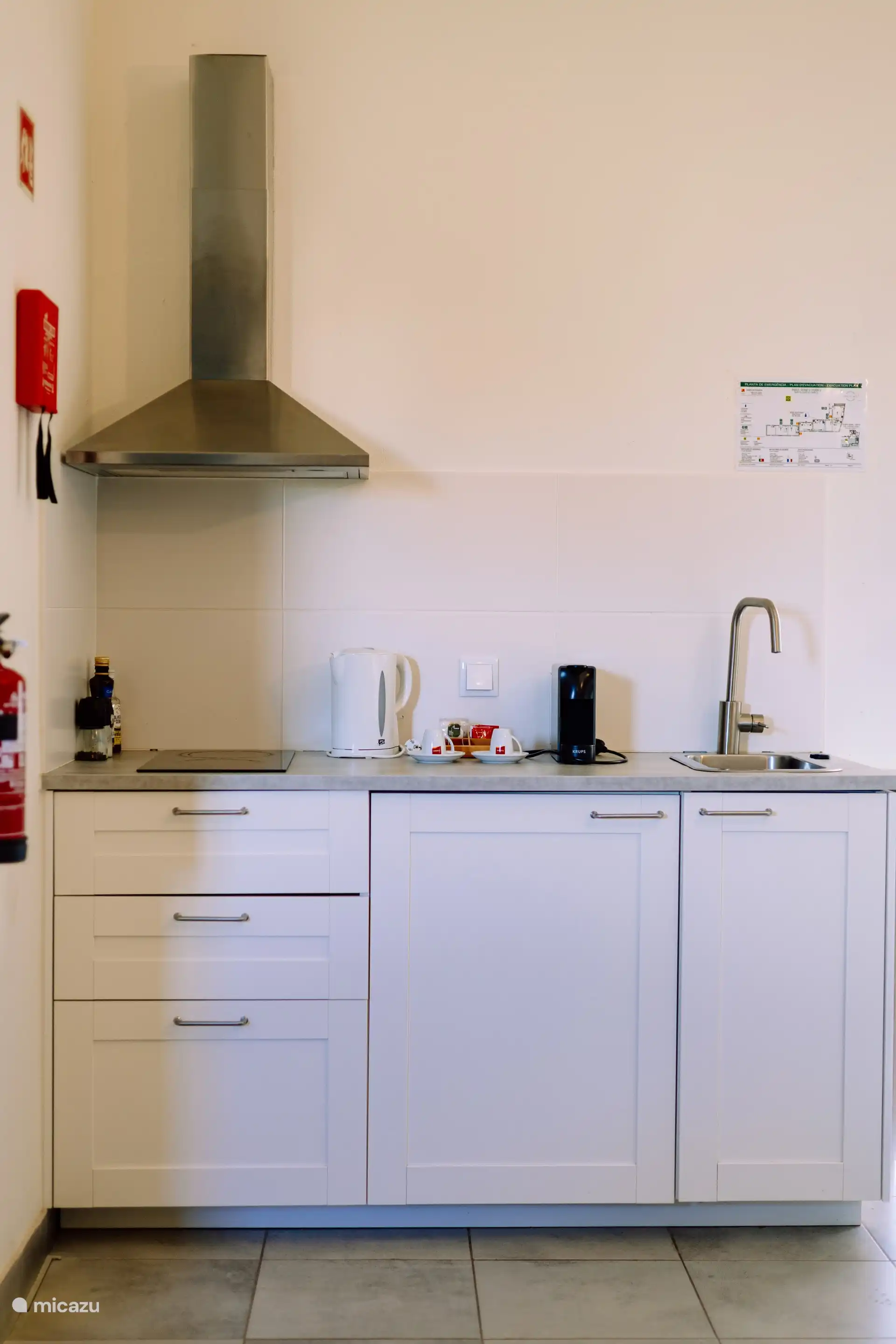 Cocina americana con vitrocerámica, nevera, microondas combi, hervidor de agua, cafetera nespresso y utensilios de cocina. 