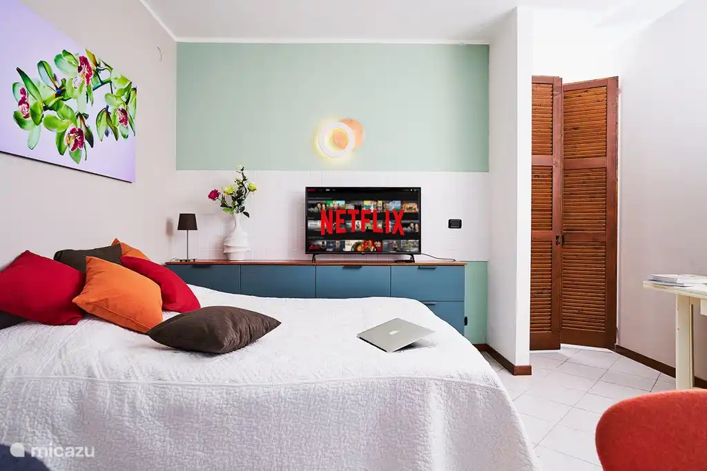 Romántica sala de estar decorada con estilo y calidez. Cama Queen size con vista al lago. Mosquiteros en el exterior de las amplias puertas del balcón.