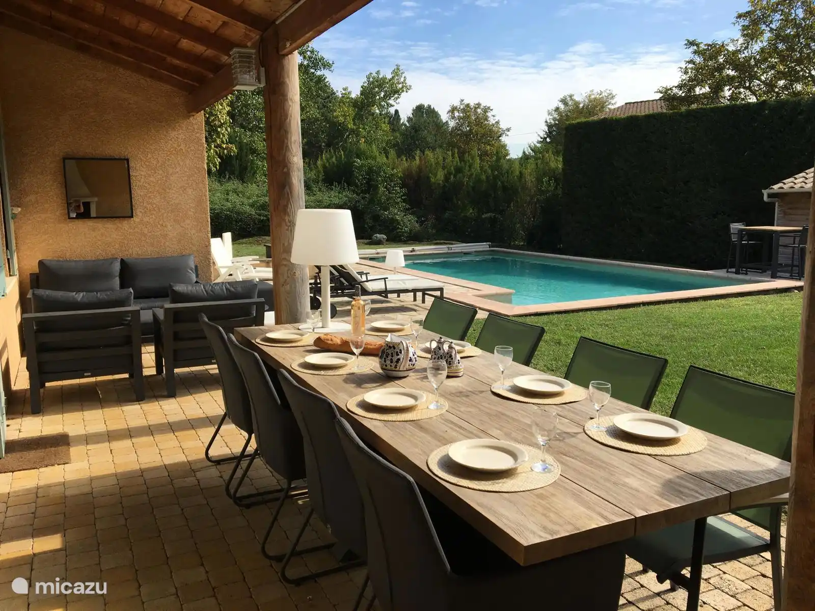 Terrasse, gedeckter Tisch, Sitzbereich, Sonnenliege und Schwimmbad