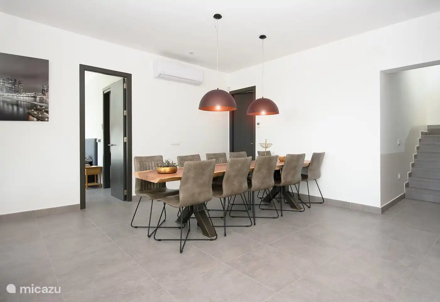 Der große Esstisch im Inneren ist ein sogenannter einteiliger Sequoia-Baumstammtisch. Ein warmes und robustes Aussehen. 10 schöne Stühle, auf denen Sie auch lange speisen können.