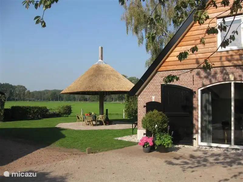 Voorzijde vakantieappartement Zuid met het terras onder de hooiberg