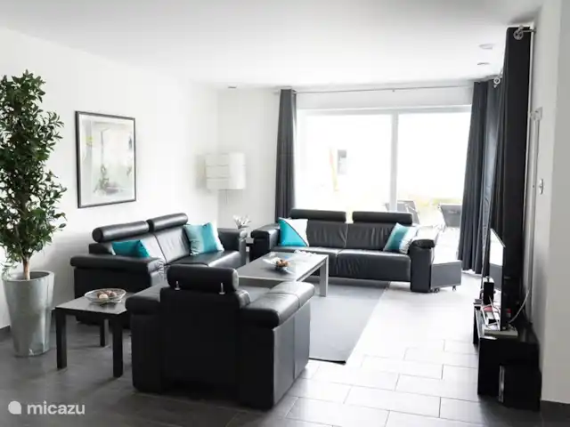 villa en Alemania, Hunsrück, Morbach – Villa Mosela El salón con invernadero contiguo, terraza, jardín y cocina abierta.