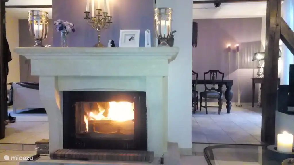 The living room. To the left of the fireplace you look in the large bedroom on the ground floor. On the right you see the dining room and the French doors to the enclosed garden and the veranda.