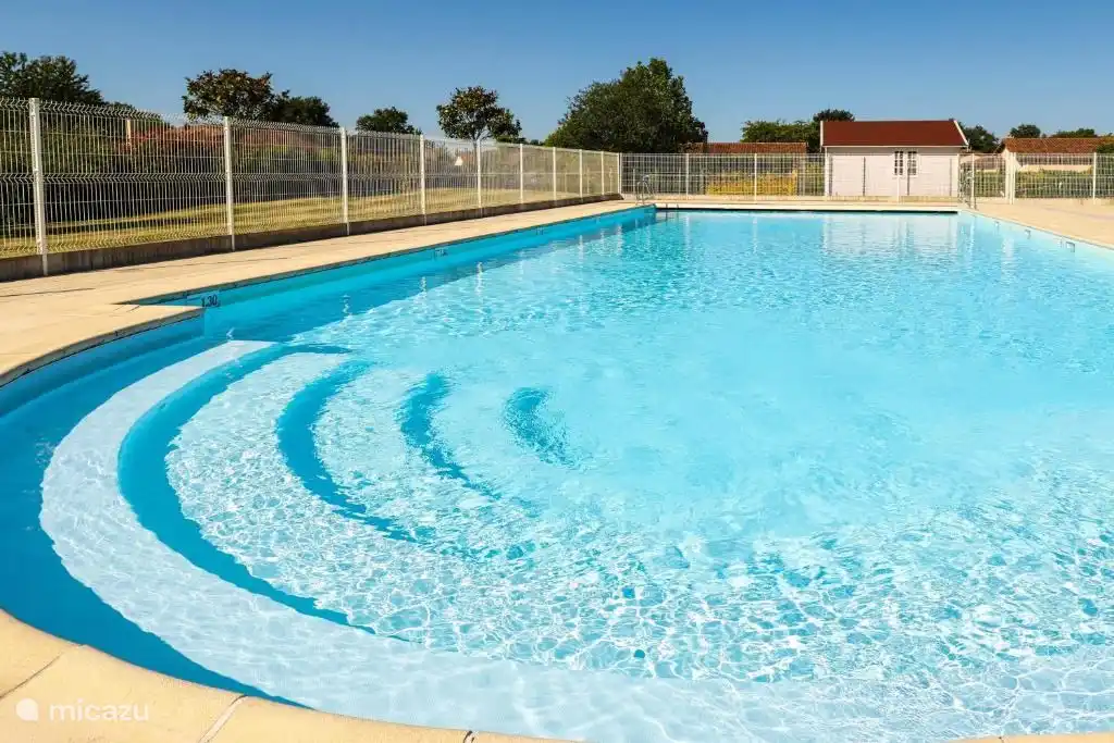 La plus grande des deux piscines. Pendant la saison de location, il y a des chaises longues, des chaises et des parasols gratuits