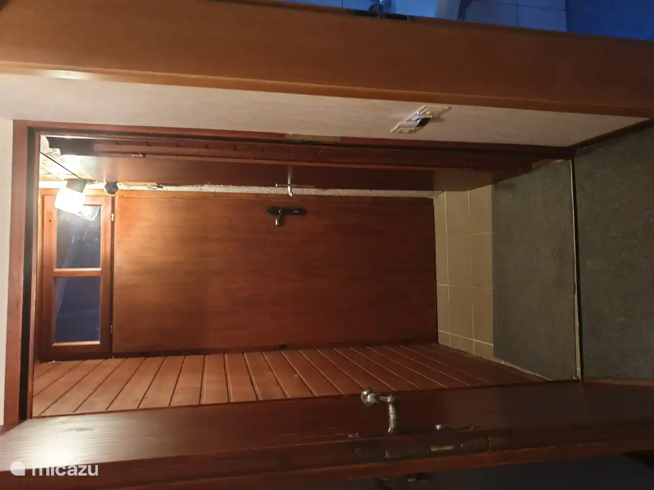 Hall con puerta exterior ya la derecha la habitación con lavadora, cuadro eléctrico, congelador y trastero.