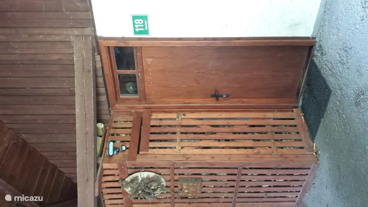 Puerta de entrada debajo de la cochera con el cobertizo de madera (pellets).