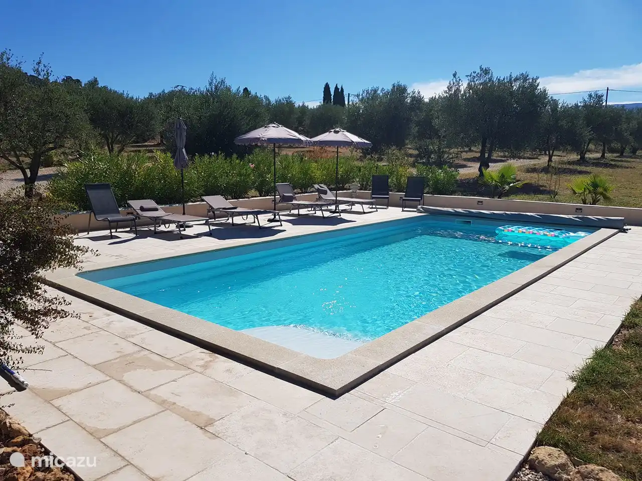 Geräumiger Pool und Terrasse mit bequemen Sonnenliegen