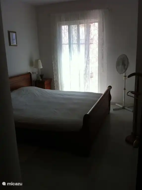 Chambre principale avec portes coulissantes, donnant sur le vieux village blanc et la mer Méditerranée.