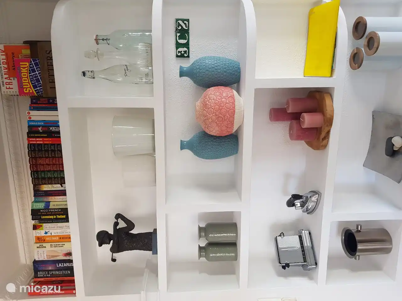 gabinete con hermosos accesorios y mini biblioteca en el estante superior