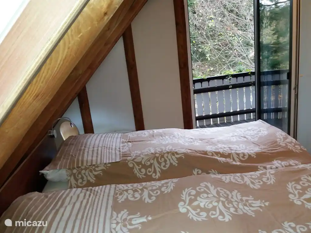 De slaapkamer op de tweede verdieping met deur naar het balkon