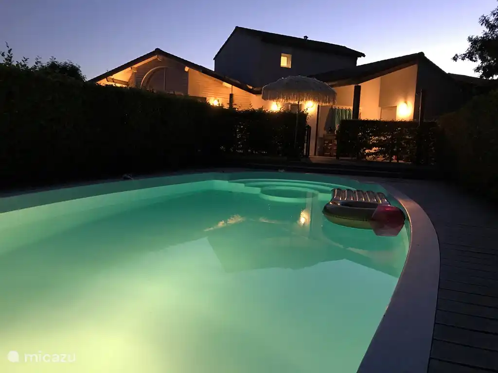 Blick auf die Villa bei Nacht, von der Sonnenliege am Pool.