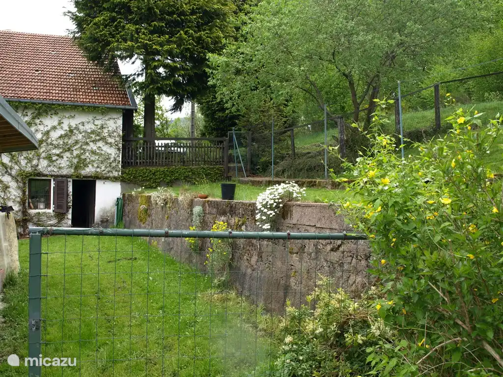 A l'arrière de la maison, ici vous entrez dans le jardin. à gauche la grange, à droite les cordes à linge et le verger.
