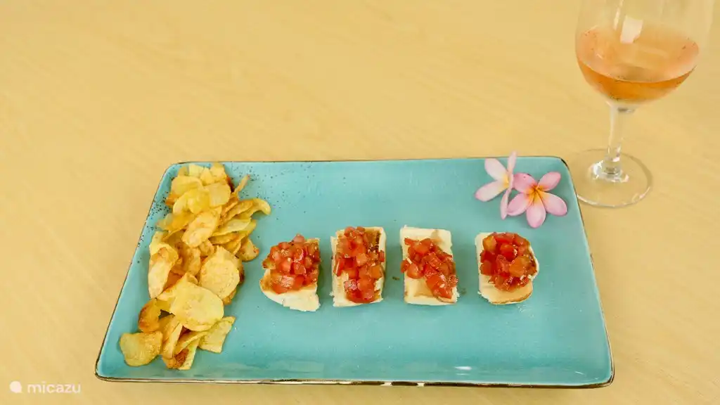 Bruchetta mit Kartoffelchips. Ein Mittagssnack mit einem Glas Rose.