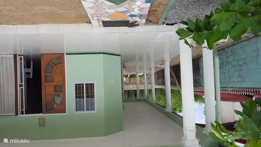 Entrada principal con terraza en forma de L de 2,5 m de ancho