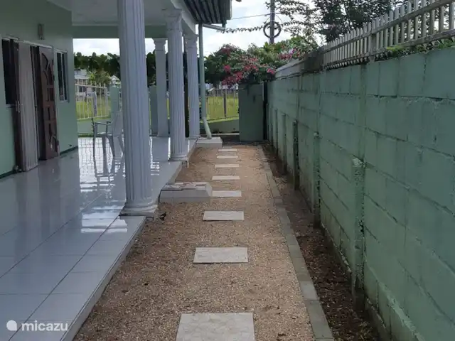 Location de Vacances Suriname, Paramaribo, Paramaribo, bungalow - Mi Dren Côté gauche à côté de la terrasse avec chemin carrelé