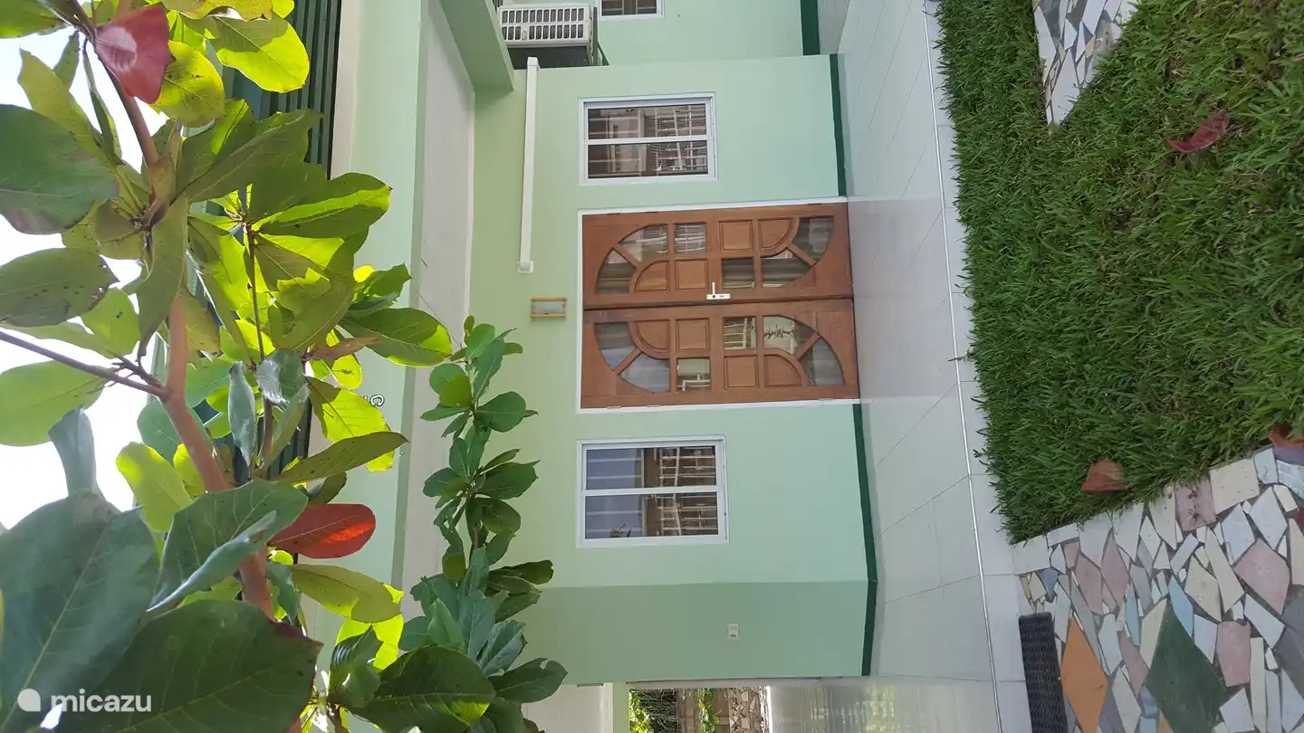 Entrada principal, césped, almendro