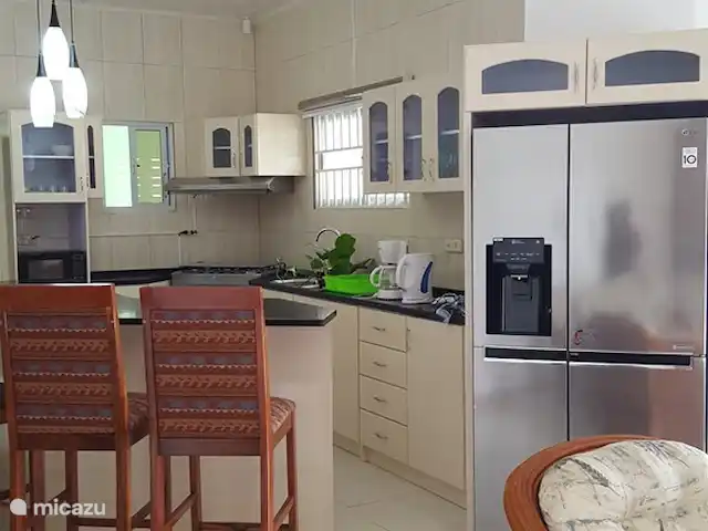 Location de Vacances Suriname, Paramaribo, Paramaribo, bungalow - Mi Dren Vue d'ensemble cuisine, îlot, table à manger, réfrigérateur avec machine à glaçons, disponible à la location à partir de 2 personnes
