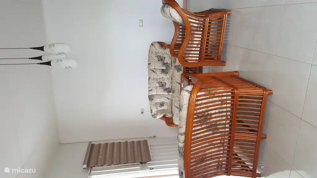 Sala de estar con muebles de mimbre, disponible para alquilar a partir de 2 personas