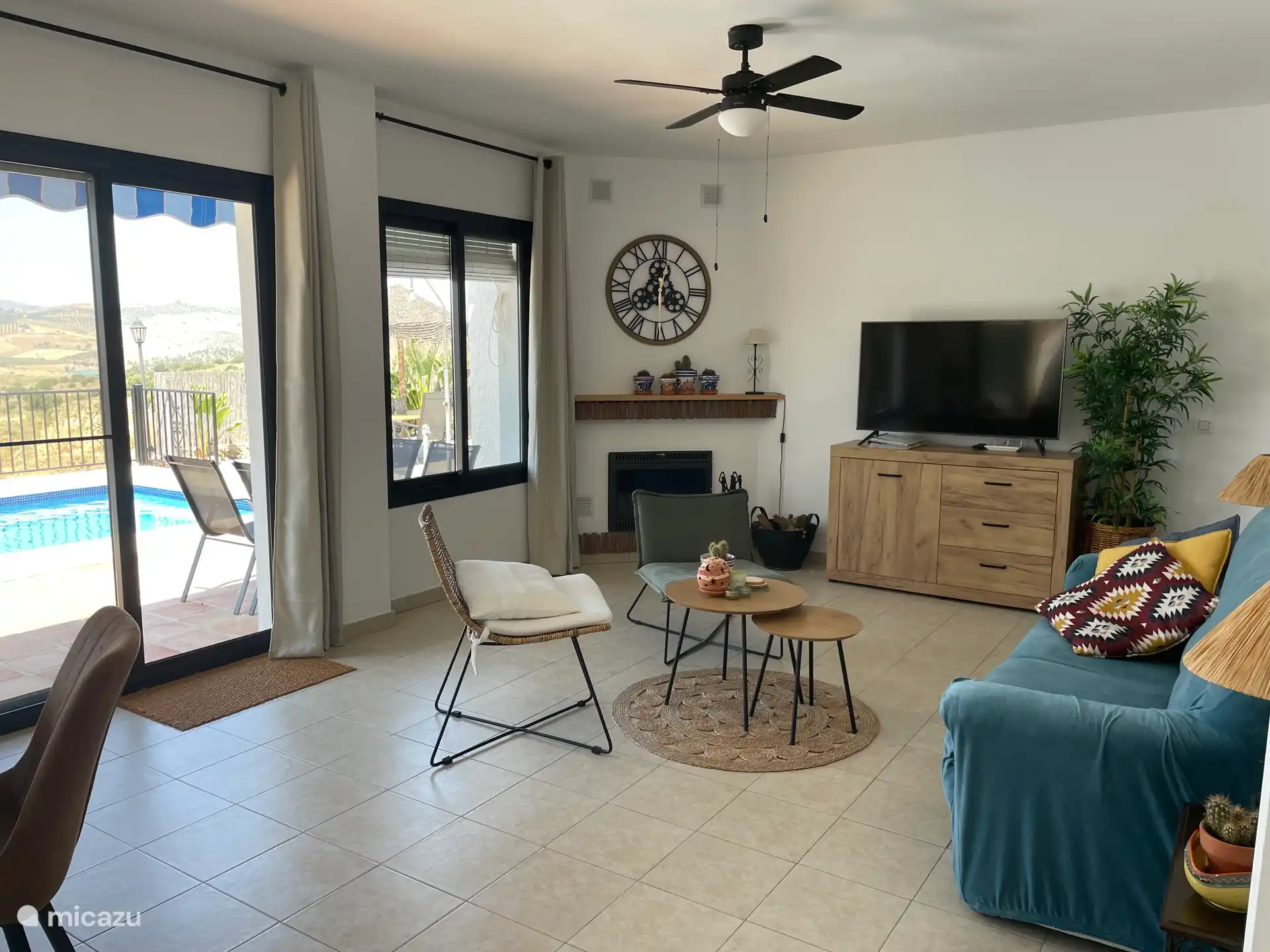 Kamin, Smart-TV, 3-Sitzer-Sofa und 2 Stühle.