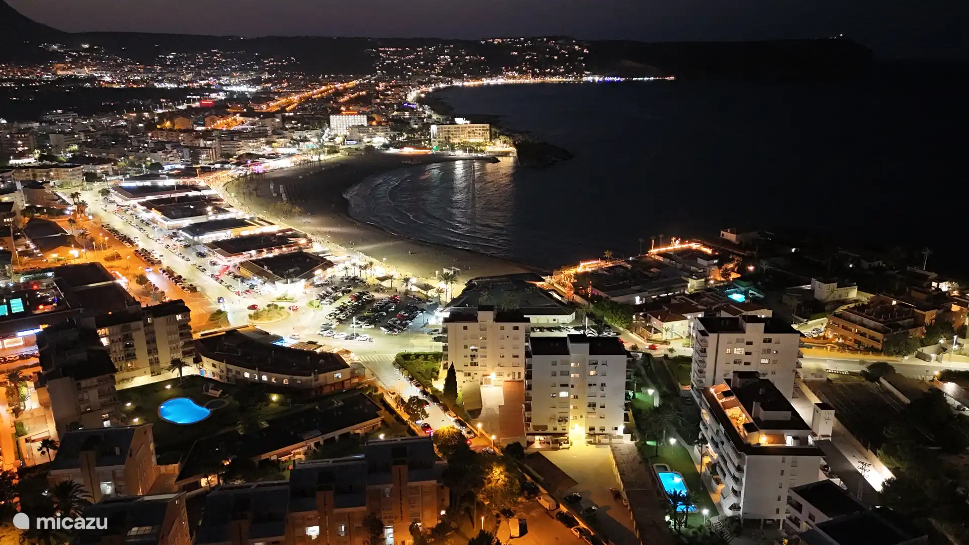 El paseo marítimo por la noche, iluminado y animado, con una magnífica vista de la bahía: un ambiente mágico lleno de convivencia