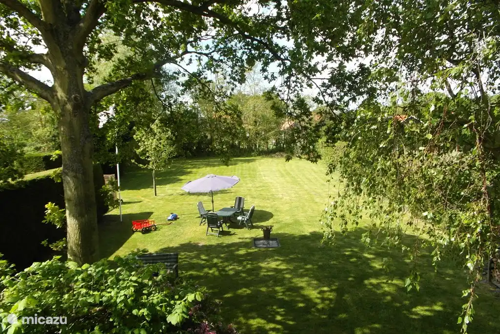 Ein großer, sonniger Garten mit Spielplatz.