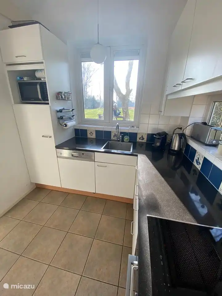 De keuken heeft ruim zicht op de tuin en het grote veld.