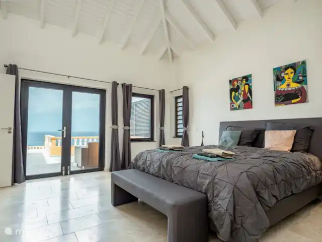 Villa Trupial huren in Curaçao, Banda Abou (west), Coral Estate, Rif St.Marie - villa Master bedroom met kingsize bed 180x210, openslaande deuren naar de porch met het zwembad