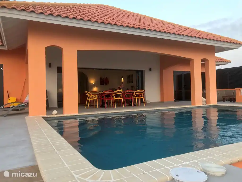 Veranda neben dem Schwimmbad. Tisch mit 10 Stühlen und 2 Loungesets