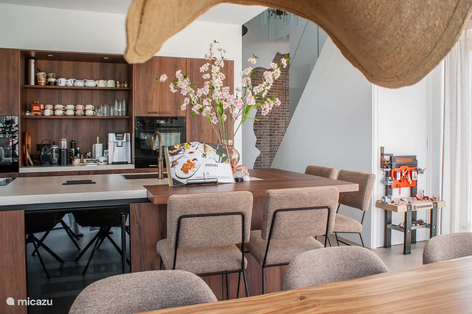 A modern kitchen island with bar chairs.