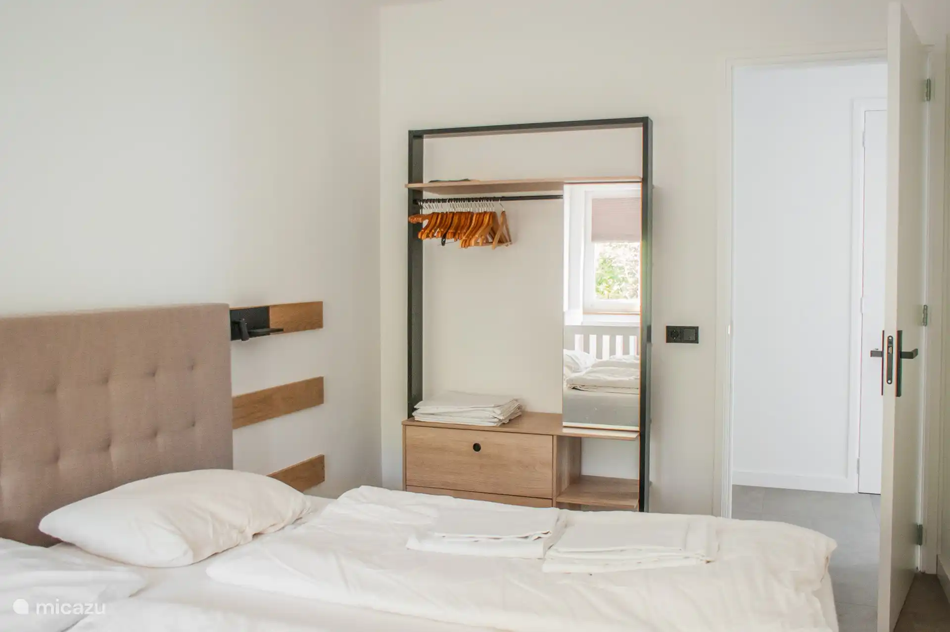 Three spacious bedrooms, each with its own sink and clothes rack.