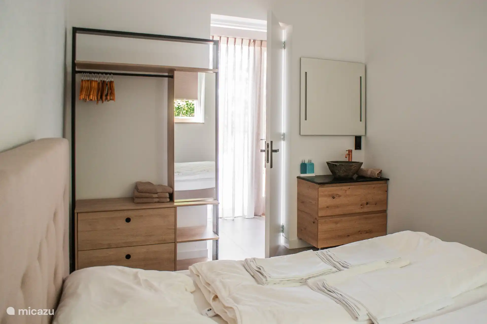 Three spacious bedrooms, each with its own sink and clothes rack.