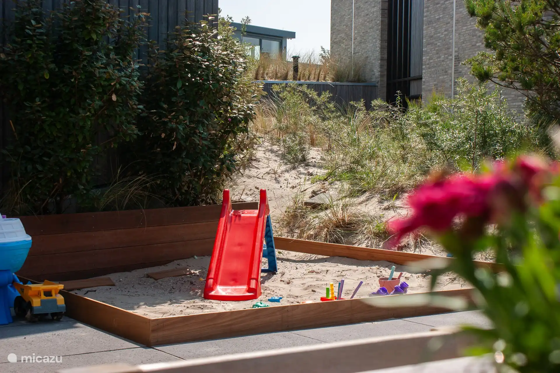 Sandpit with slide and outdoor toys.