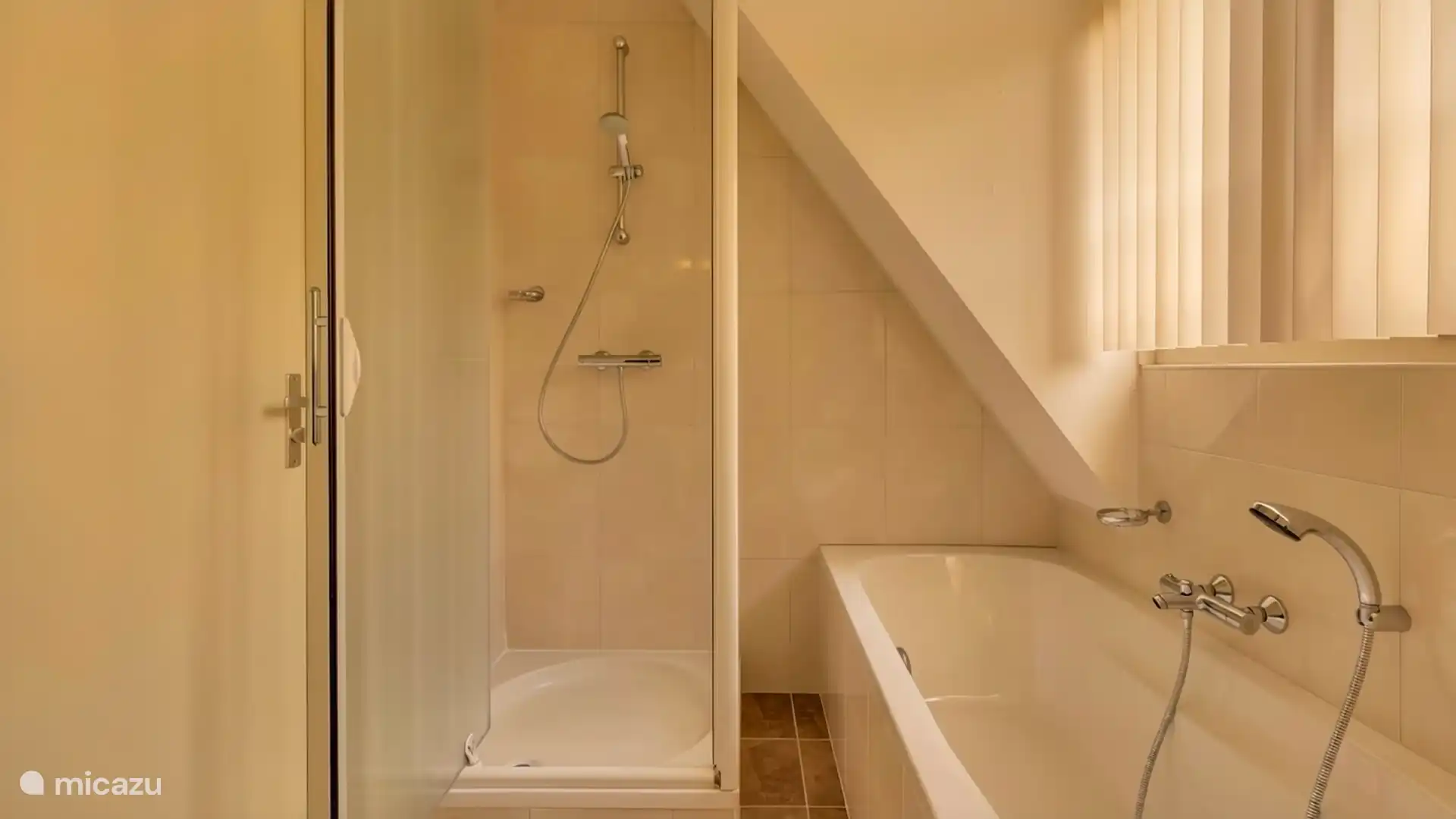 Badkamer op de eerste etage met wastafel, douchecabine, ligbad en toilet.