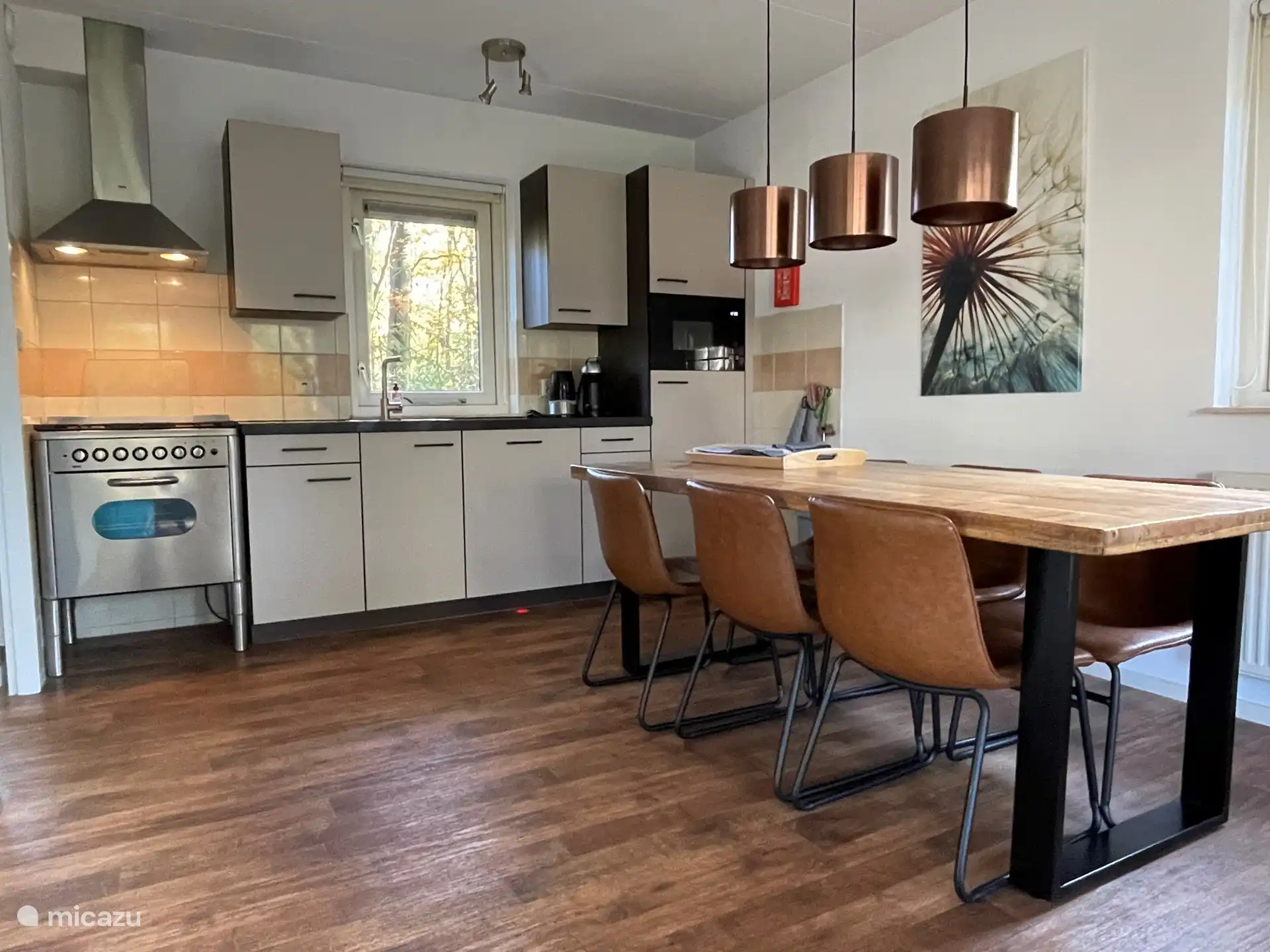 A modern open kitchen with dishwasher, oven and microwave and a spacious dining table for cozy dinners.