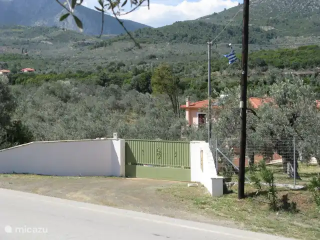 Grèce divine - App. Haut de page | Grèce, Péloponnèse, Archaia Epidavros - maison de vacances le portail d'entrée avec drapeau sur le poteau téléphonique qui sert de repère.