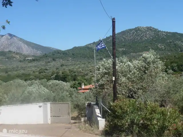 Grèce divine - App. Haut de page | Grèce, Péloponnèse, Archaia Epidavros - maison de vacances le portail d'entrée avec drapeau sur le poteau téléphonique qui sert de repère.