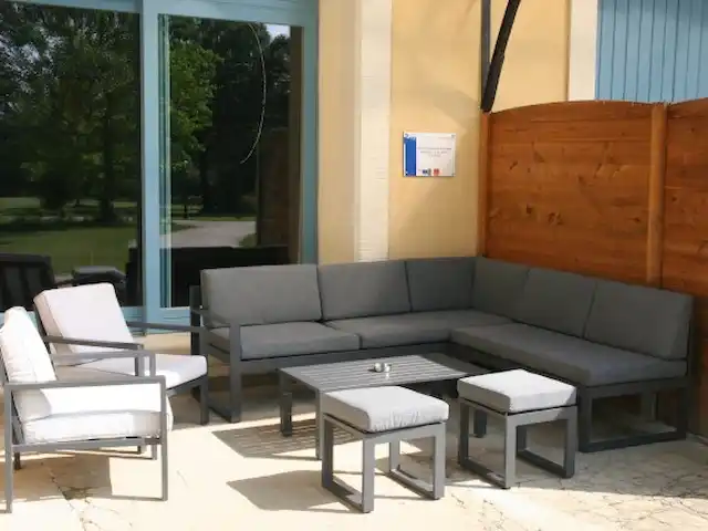 Castillo Portos en el sur de Francia en Francia, Tarn, Cahuzac - casa vacacional Asientos lounge: acogedor rincón de aperitivos bajo techo en la parte delantera de la casa de vacaciones con vista al castillo y al jardín del castillo