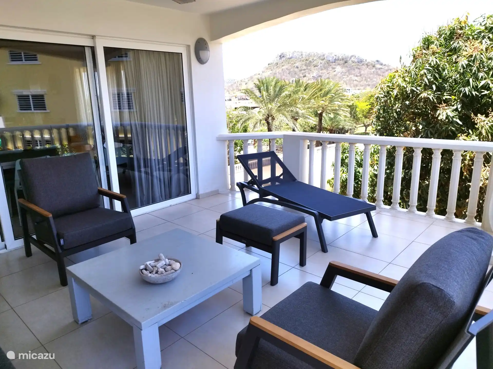 spacious balcony with a balcony that is well exposed to the wind, with a longe set to relax on.