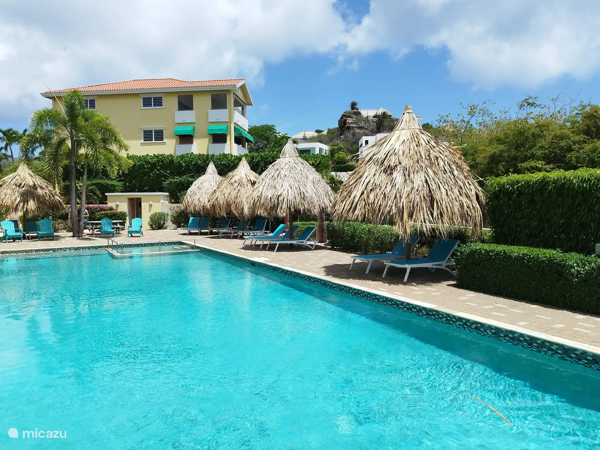 swimming pool at the apartment, with palapas for nice shade.
