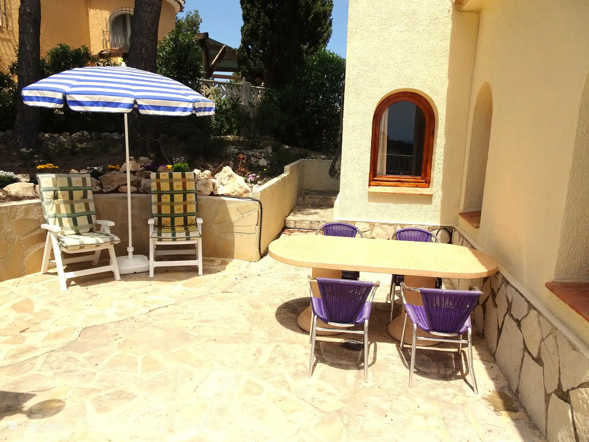 Charmant coin petit déjeuner à l’ombre avec très grande table.