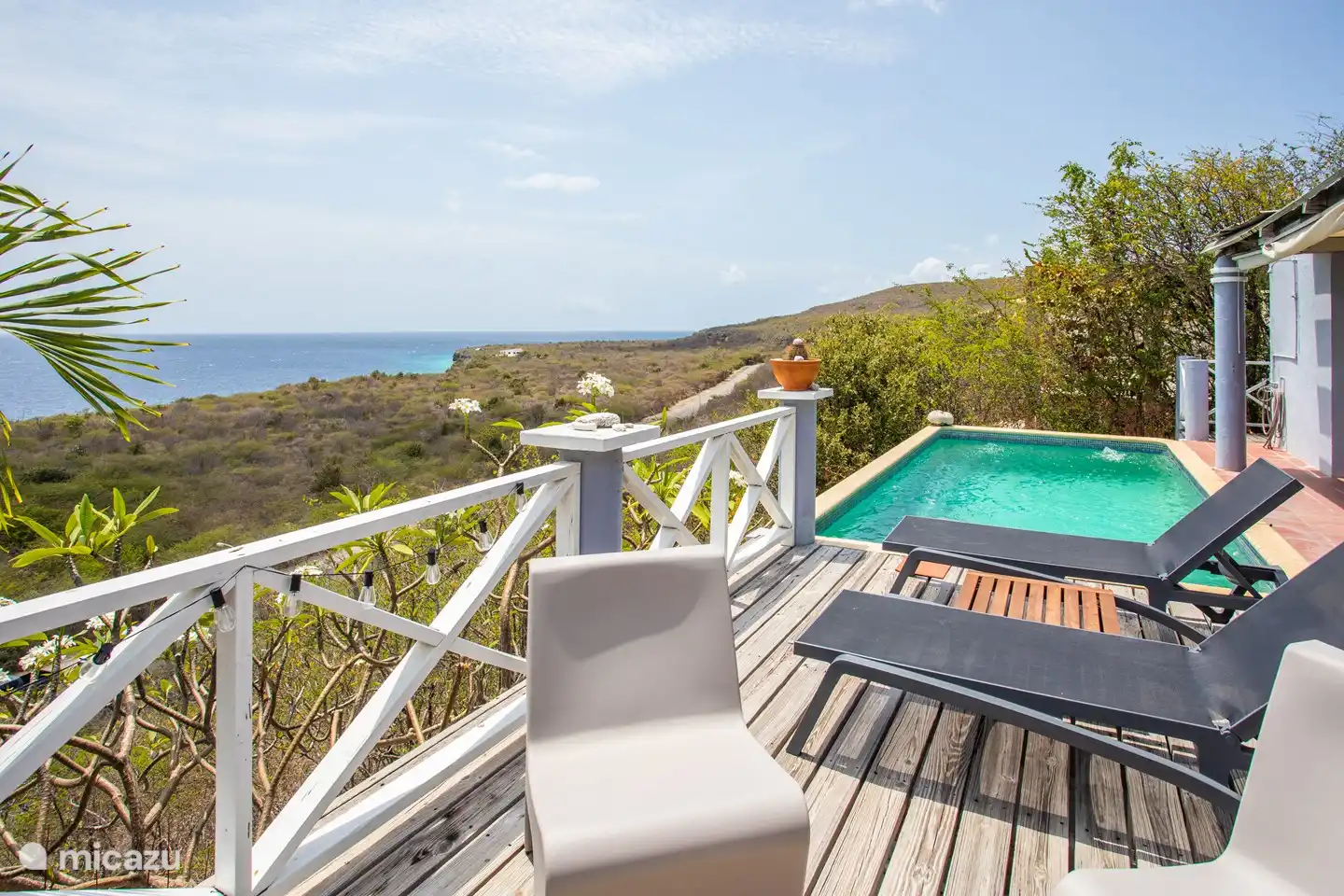 Terrasse de la piscine et coin salon avec vue sur la mer