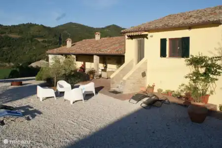 Vakantiehuis Italië, Marche, Fossombrone appartement Casa Gialla Sopra voorzijde huis met overdekte veranda