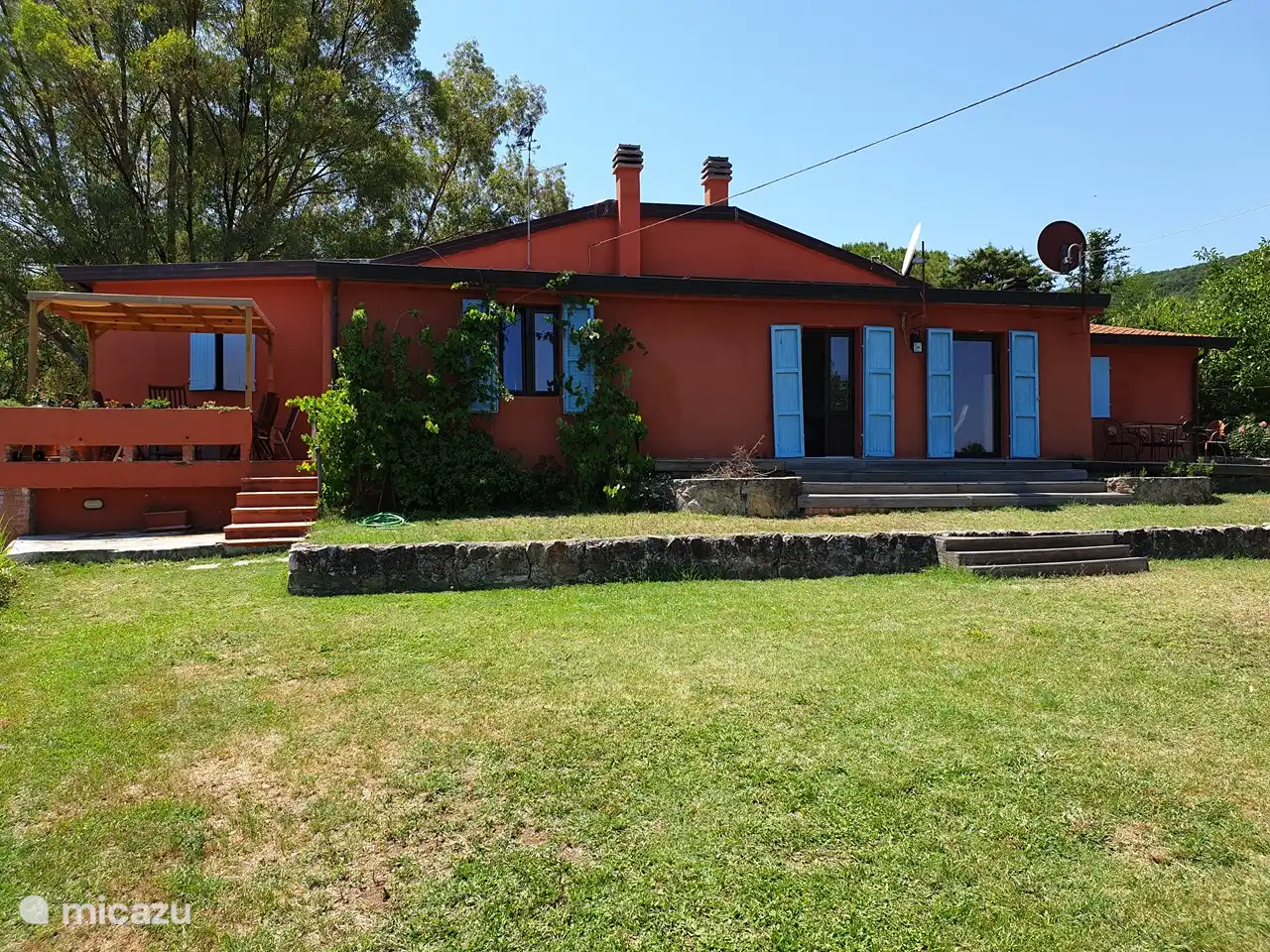 Parte trasera de la casa y césped a la piscina.