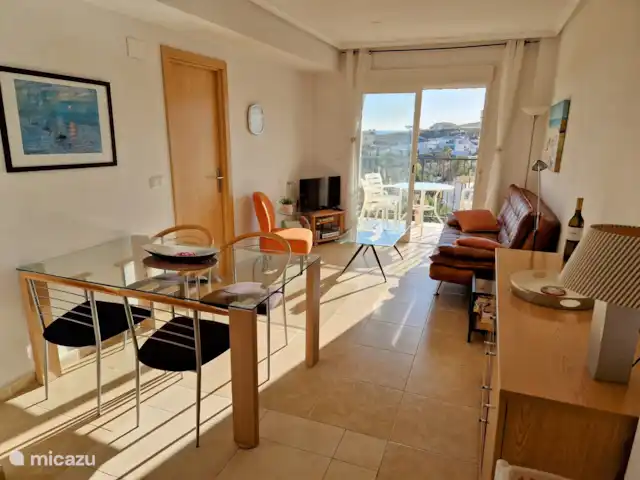 VUE MER ENSOLEILLÉE avec grande terrasse sur le toit | Espagne, Costa Blanca, El Campello - appartement Salon, adjacent au balcon avec vue imprenable sur la mer, vue sur la piscine et le jardin. Ambiance charmante. TV avec toutes les chaînes néerlandaises et de nombreuses chaînes étrangères. Internet par fibre optique.