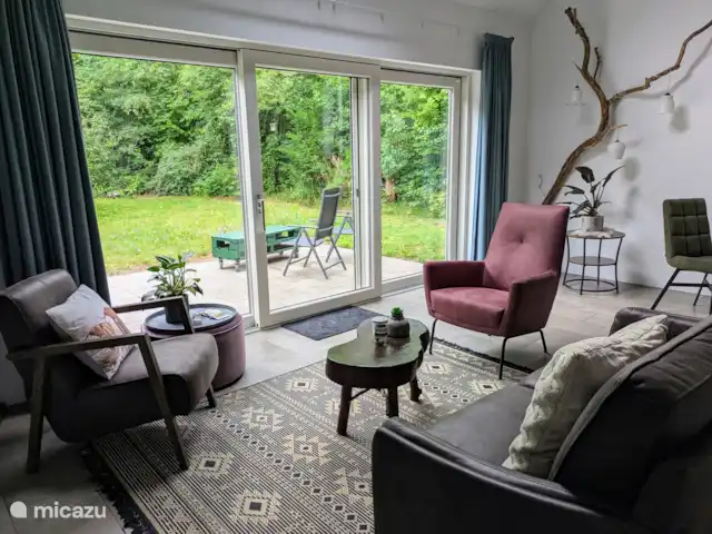 BuitenGewoon huren in Nederland, Drenthe, Westerbork - vakantiehuis Een overzicht van de kamer gedeelte.  Vanaf de 2 zit-bank kijk je de tuin en het bos in.
