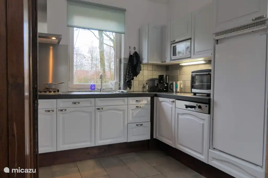 Luxuriöse offene Küche mit vollem Dekor und Blick auf das Spielfeld.