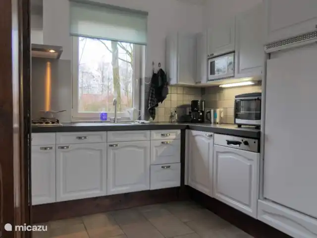 BuitenGewoon huren in Nederland, Drenthe, Westerbork - vakantiehuis Luxe open keuken met volledige inrichting en uitzicht op speelveld. De grote koelkast heeft een klein vriesvak. Koffie, thee en suiker is altijd op voorraad.