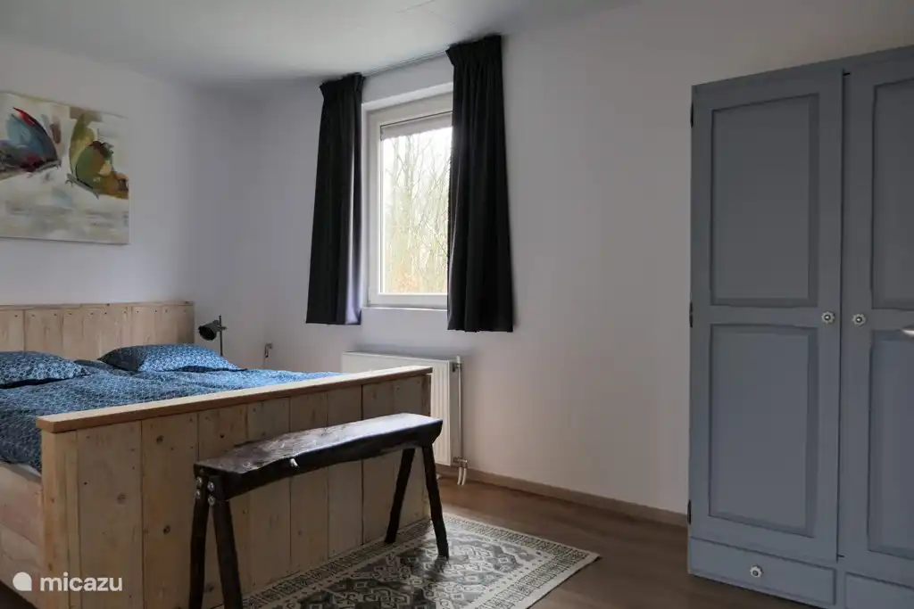 Schlafzimmer mit einem robusten Gerüst-Holzbett für 2 Personen mit beweglichem Bettgestell und 1-Personen-Bettdecke. Dank dem bequemen Bett und der Stille rund um das Ferienhaus können Sie bequem schlafen. Vor den Schlafzimmerfenstern befinden sich feste Bildschirme, sodass Sie nachts bei geöffnetem Fenster schlafen können.